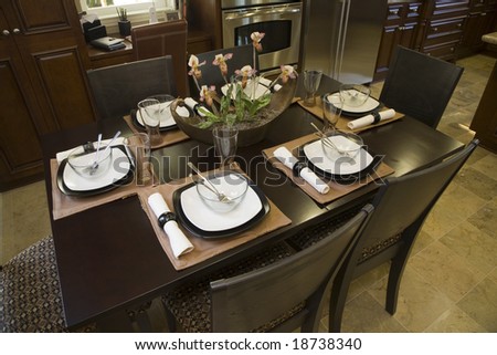 Dining table with modern tableware and decor.