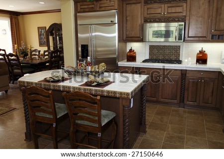 Modern designer kitchen with brown tiles and a granite island.