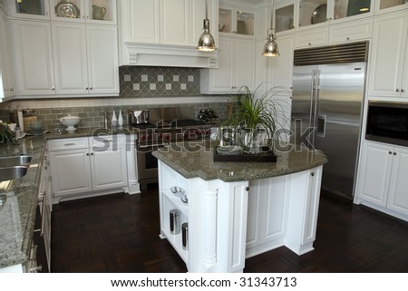 Modern designer kitchen with a hardwood floor and granite island.