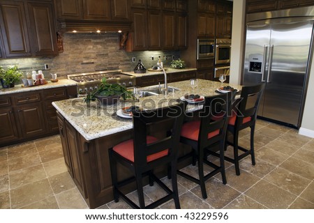 Luxury home kitchen with a granite breakfast counter.