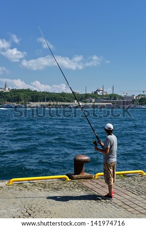 ISTANBUL, TURKEY - JUNE 9; Senior men fishing from the pier Beyoglu at sunset on 9 June 2012 in Istanbul, Turkey. Istanbul is located within Marmara Region on a total area of 5,343 sq km.