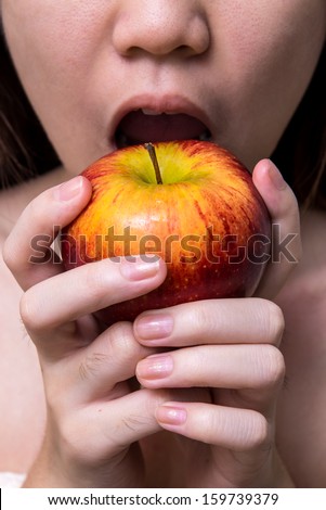 holding red apple to bite , girl bite apple , white backdrop