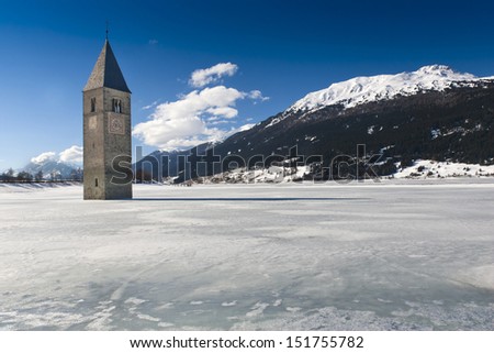 Winter scene at Lake Reschen with sunken gray steeple. Lake Reschen is an artificial lake located in the western portion of South Tyrol, Italy, near the Reschen Pass.
