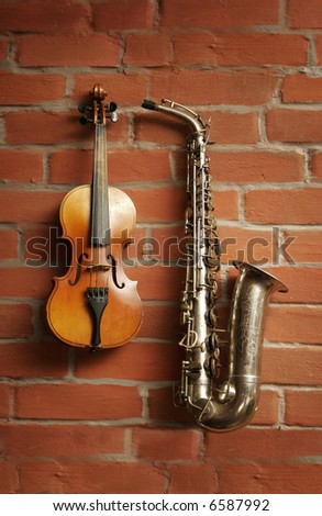 Violin & saxophone over red brick wall
