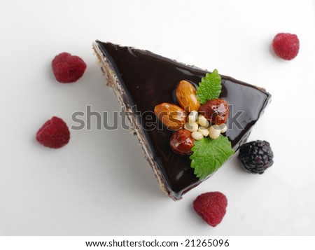 piece of cake with nuts coated with chocolate icing (view from above)