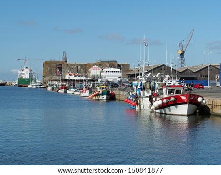 SAINT NAZAIRE, FRANCE - CIRCA AUGUST 2013:  harbor with fishing boats and World War II blockhaus, circa August, 2013. Saint Nazaire submarine base was one the five built by the third Reich in occupied France.