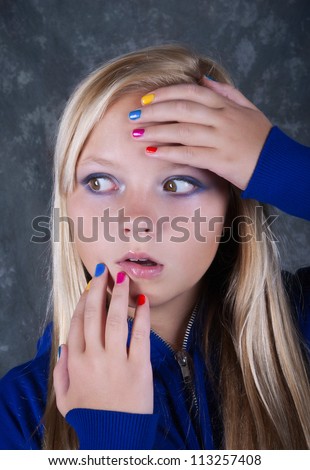 Very surprised beautiful  girl with hands which has colored nails