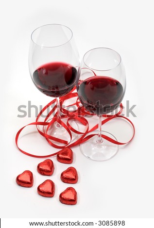 Two goblets with red wine, tape and sweetmeat as heart