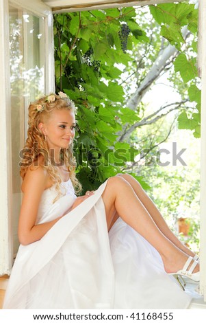 Beautiful smiling caucasian bride. Seated in the window