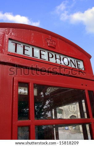 Classic red British telephone booth against blue sky