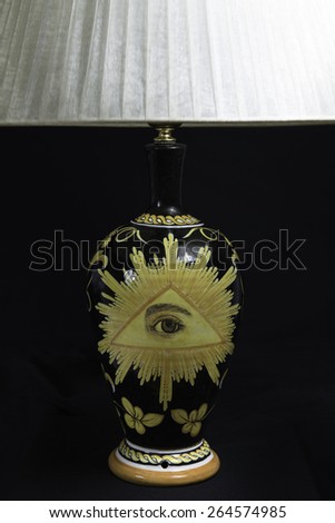 A ceramic black masonic lamp with classical masonic symbols: the eye in the triangle and the acacia