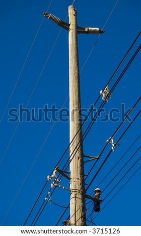Electric power lines with telephone lines on wooden pole.