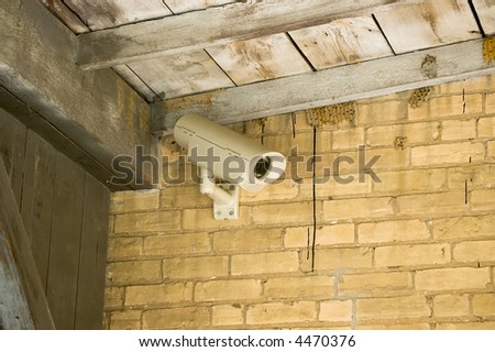 A security camera in a rural building with wasp nests
