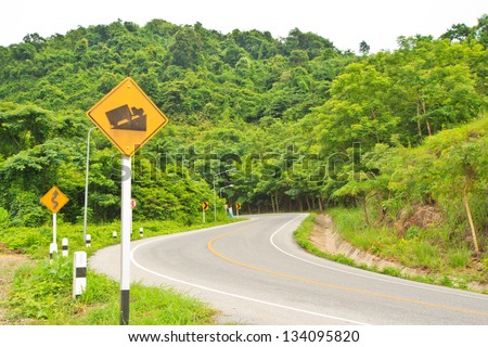yellow traffic signs and road near mountain