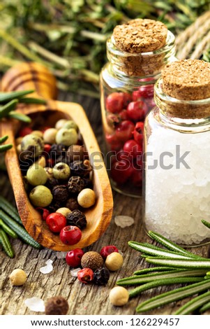 Herbs, salt and different kinds of pepper on wooden table