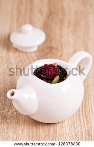 Green tea with fruits, spices, rose petals in white teapot