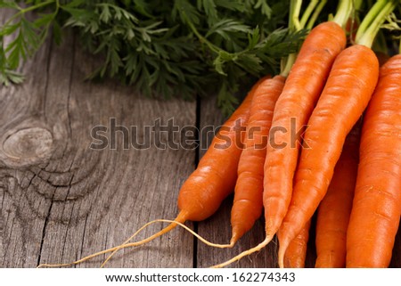 Fresh Carrot With Green Leaves On Wooden Table