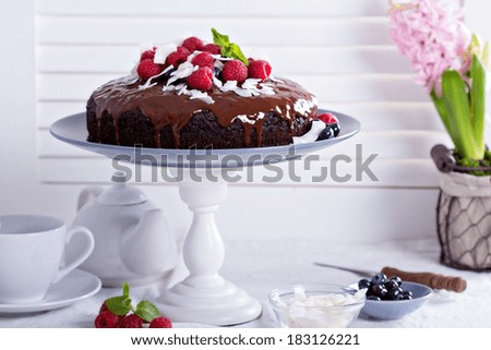 Vegan chocolate cake with berries and coconut on top Vegan chocolate cake with berries and coconut on top