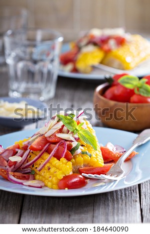 Salad with baked corn, tomatoes, almonds and onion