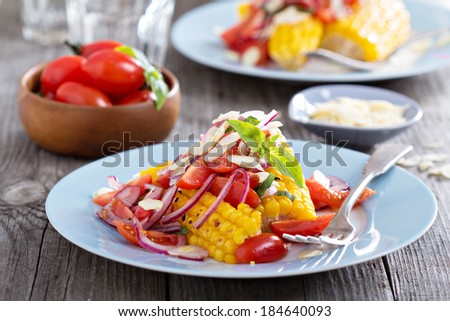 Salad with baked corn, tomatoes, almonds and onion