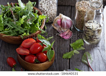 Tomatoes, salad leaves, beans and rice on a wooden table