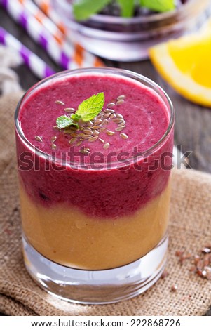 Two layered smoothie with peach, orange and blackberries