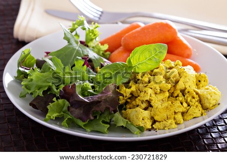 Scrambled tofu with salad leaves and carrot for breakfast
