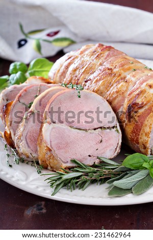 Roasted pork tenderloin with baked garlic, herbs and bacon