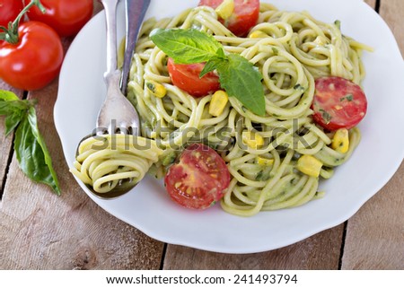 Vegan pasta with avocado sauce, tomatoes and corn