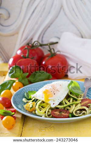 Zucchini noodles with tomatoes and pesto with egg on top