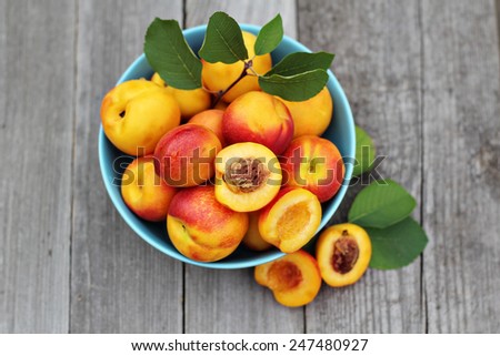Fresh peaches in blue bowl on wooden table