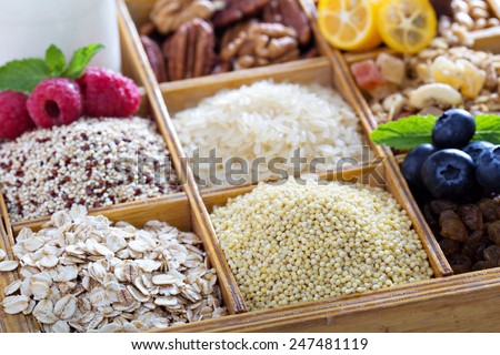 Breakfast items in wooden box with grains and berries
