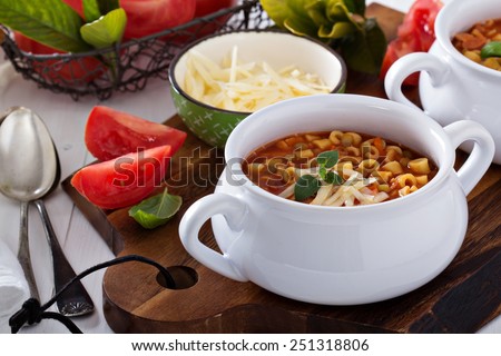 Soup with lentils, pasta and tomatoes topped with cheese