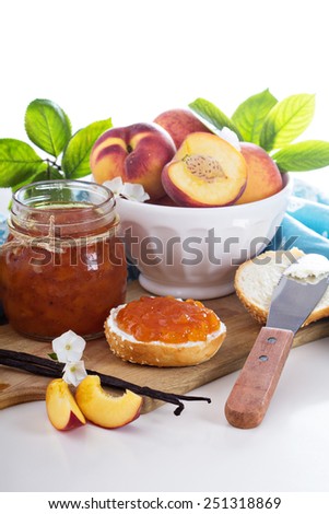 Peach vanilla jam with fresh peaches on table