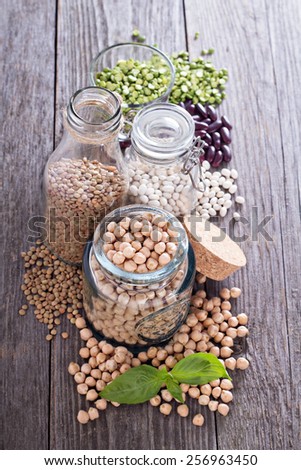 Raw beans and lentils in glass jars and bottles