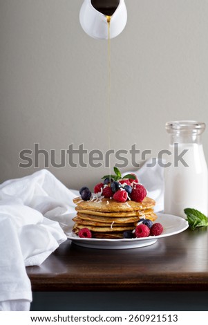 Coconut flour pancakes with fresh berries and coconut flakes