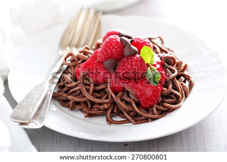Cooked chocolate pasta spaghetti with raspberry sauce