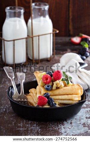 Thin pancakes with apples, honey and fresh berry