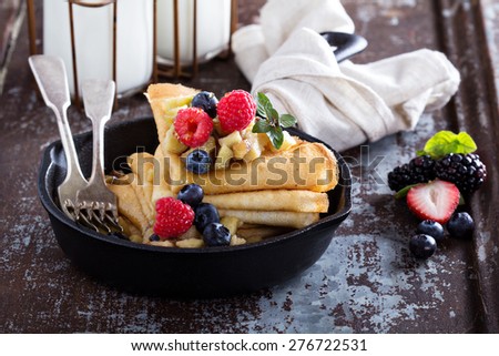 Thin pancakes with apples, honey and fresh berry