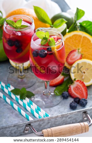 Ice cold red sangria with citrus fruits and berries in glasses