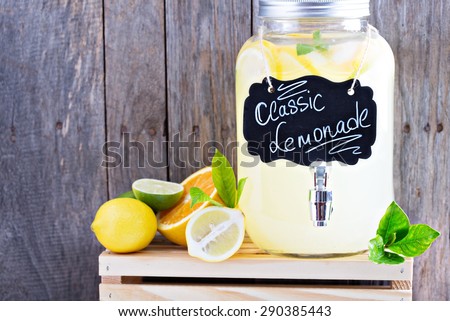 Homemade lemonade in beverage dispenser with fresh lemons