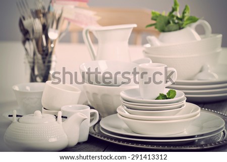 Variety of white dinnerware: plates, cups and bowls toned image