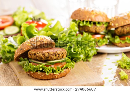 Vegan burgers with lentils and pistachios stacked on a cutting board