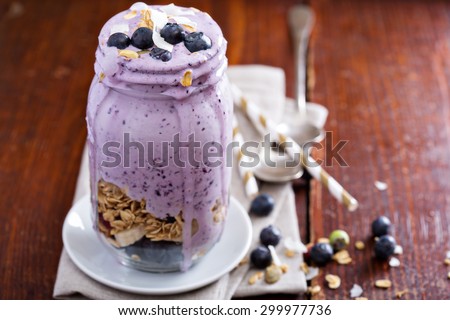 Blueberry smoothie with fruits and granola in jar