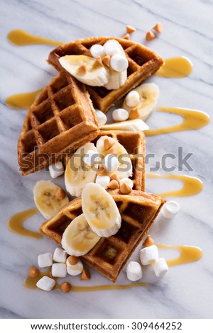 Waffles with peanut butter and bananas topped with caramel syrup