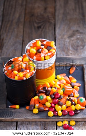 Halloween candy in small tins on brown rustic table