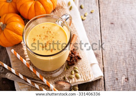 Healthy pumpkin smoothie in big mugs on rustic background