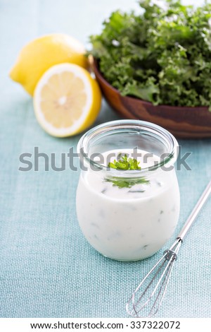 Homemade ranch dressing in a small jar with herbs