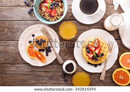Breakfast table with waffles, granola and fresh berries