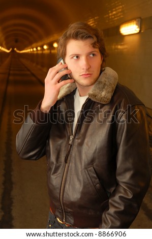 young adult in his 20s getting a mobile phone call in the old elbtunnel of hamburg.